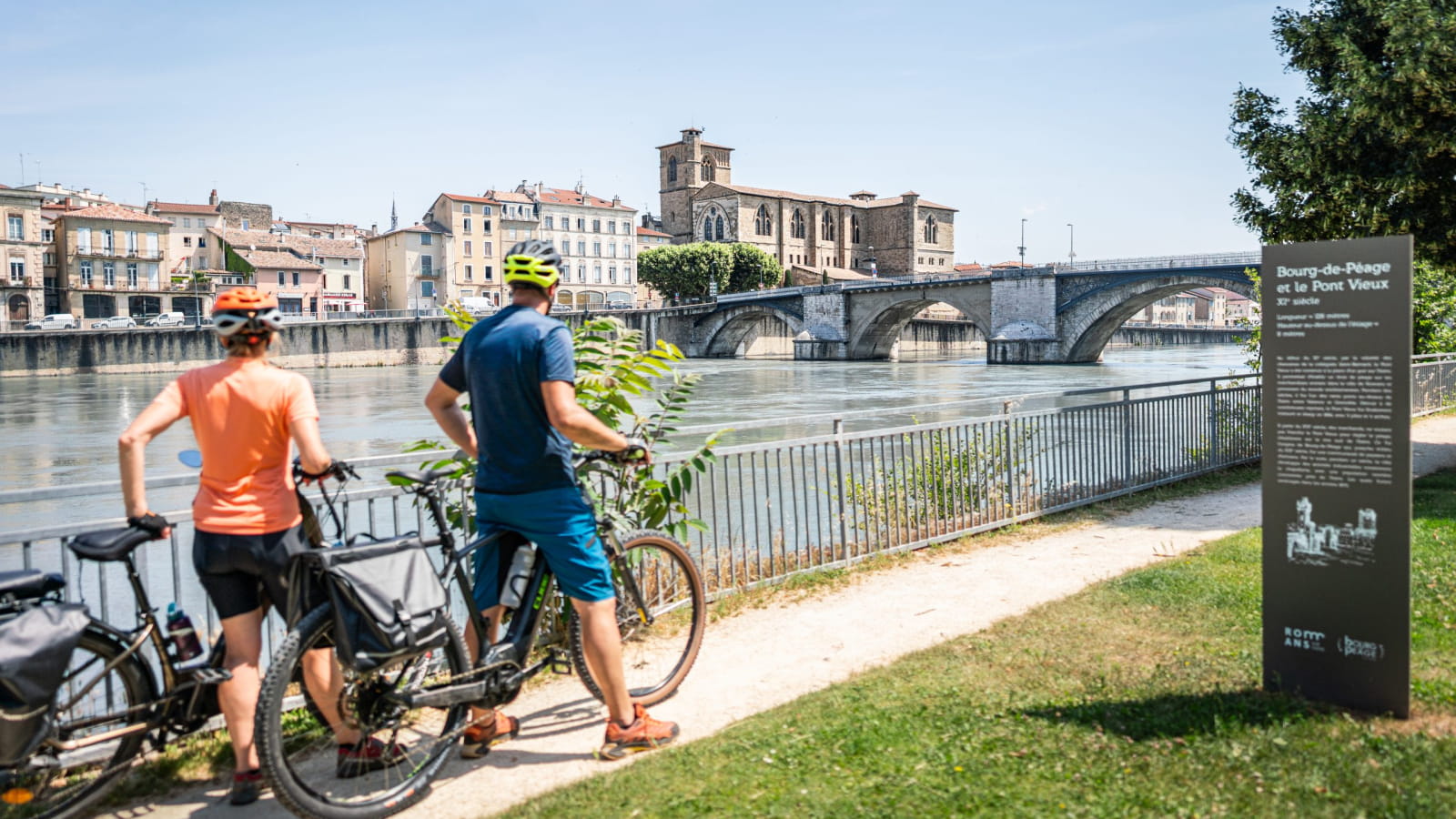 Cyclistes sur la Belle Via devant la collégiale Saint-Barnard à Romans-sur-Isère dans la Drôme