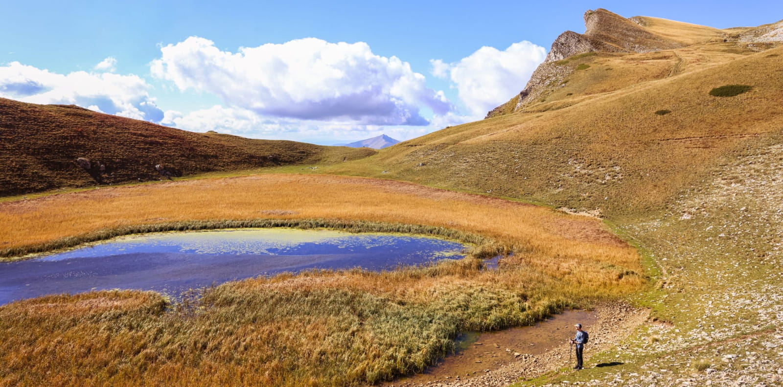 Un randonneur au bord du Lac du Lauzon, vers le Vallon de la Jarjatte