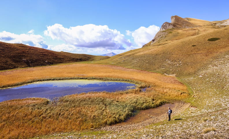 Un randonneur au bord du Lac du Lauzon, vers le Vallon de la Jarjatte